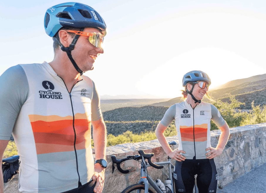 Two riders showing the desert-tone jerseys at a scenic overlook