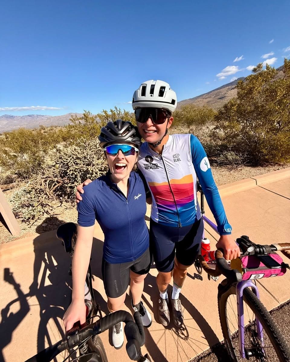 Two cyclists in the desert, one wearing the long-sleeve sunset jersey