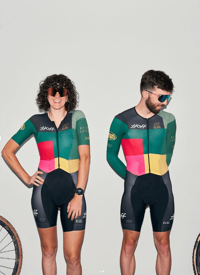 Two riders wearing green, pink, and yellow Hoff cycling kits