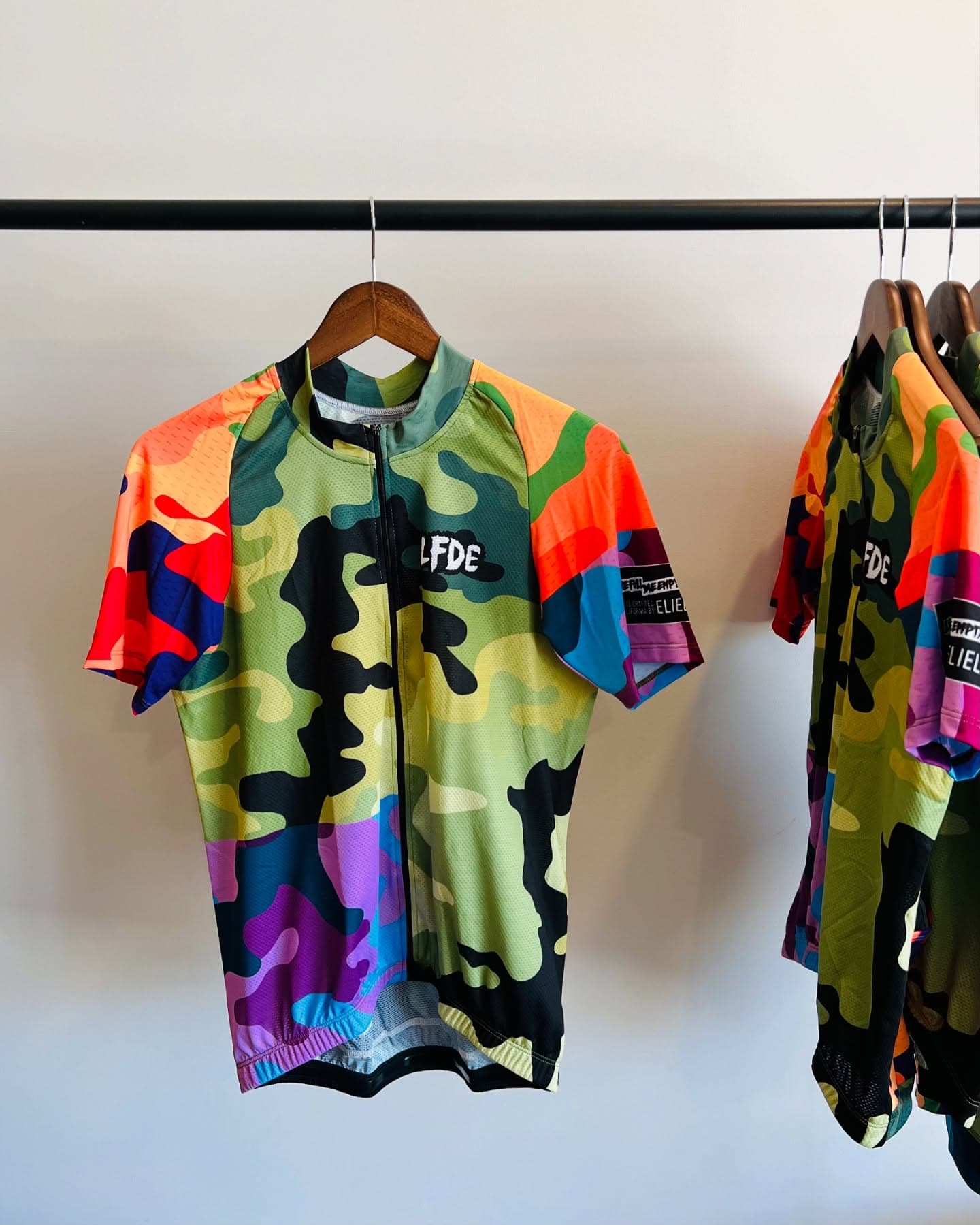 Colorful LFDE cycling jersey hanging on a rail