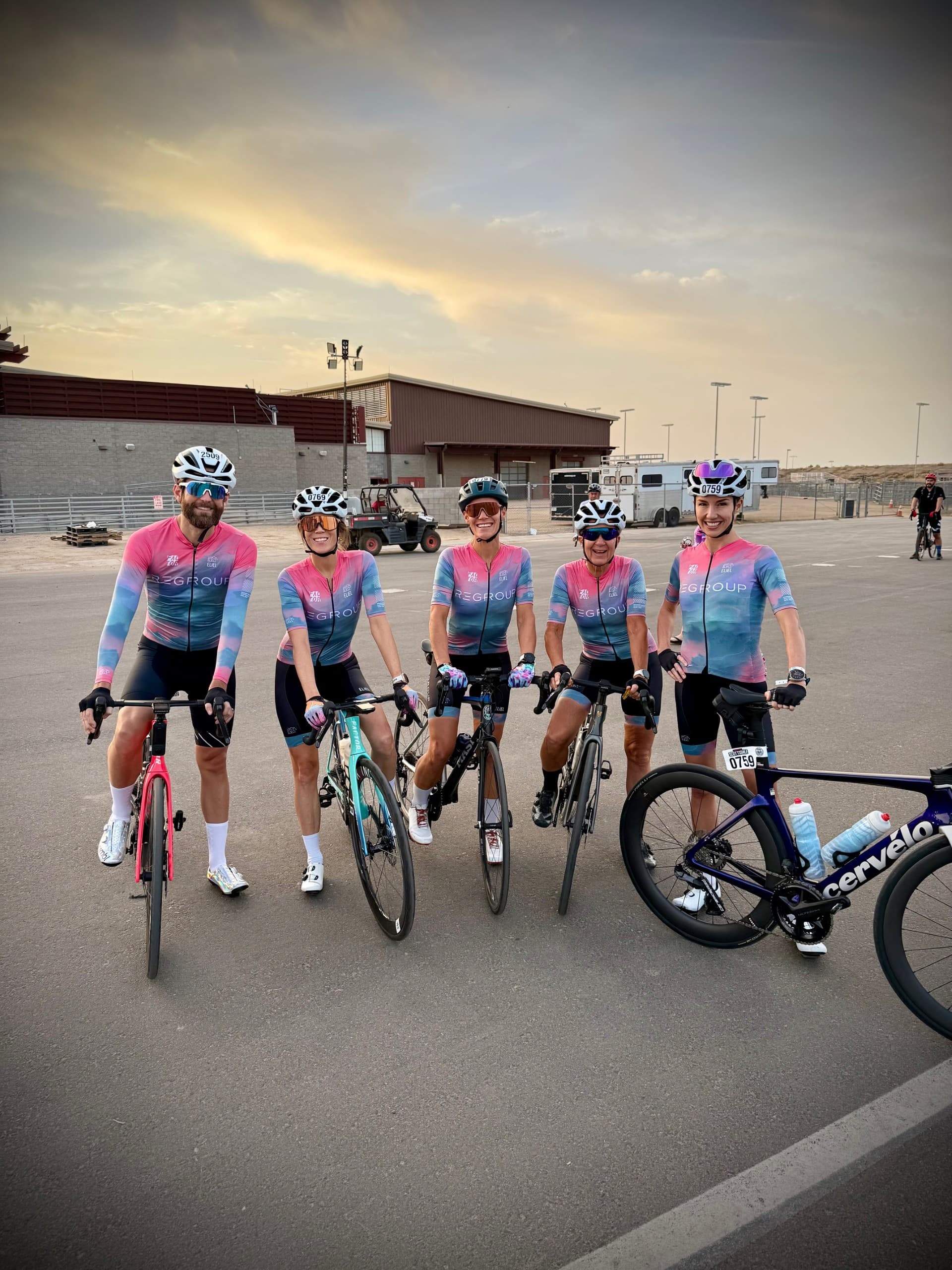 Cyclists wearing the final pink, lilac, and blue Regroup kit at an outdoor event