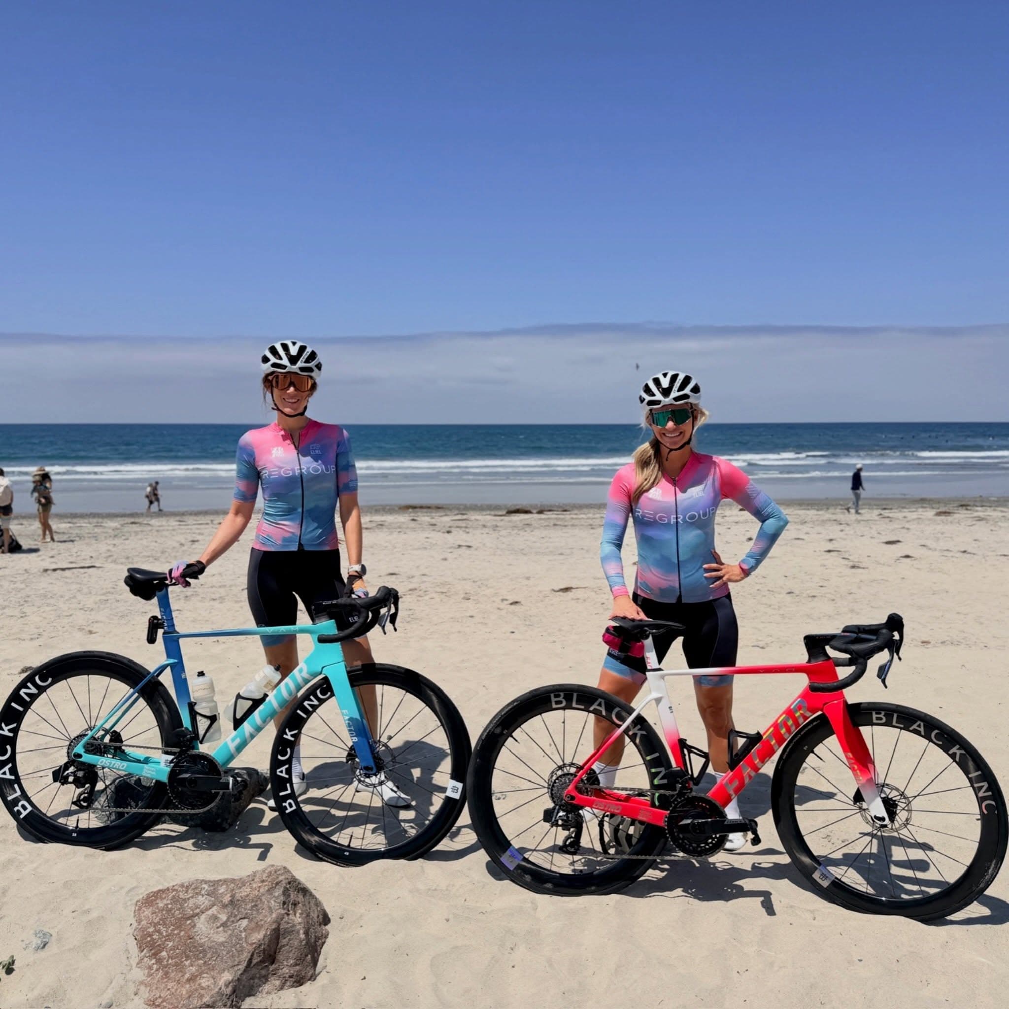 Two Regroup cyclists with their road bikes at the beach